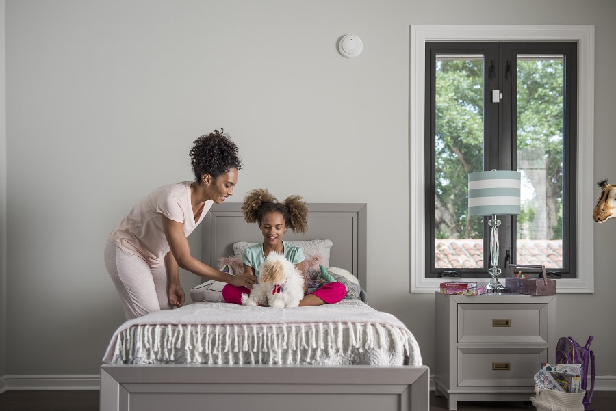 mother/daughter at bedtime with smoke sensor